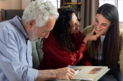 Retired couple with financial adivsor sitting at a desking signing paperwork.